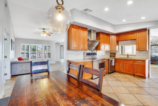 kitchen with decorative backsplash, stove, stainless steel dishwasher, wall chimney range hood, and decorative light fixtures