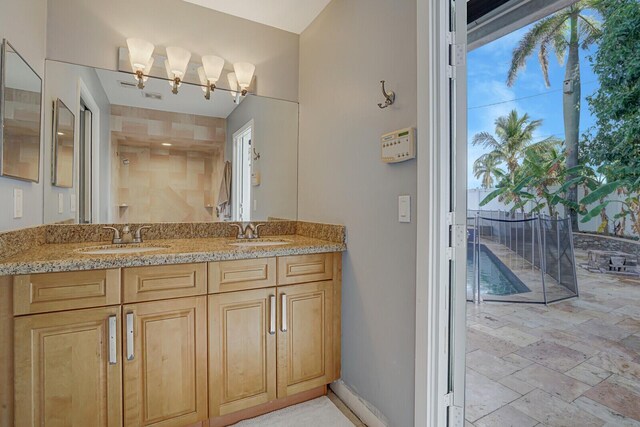 bathroom with vanity and tiled shower