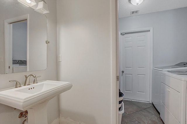 bathroom with sink and independent washer and dryer