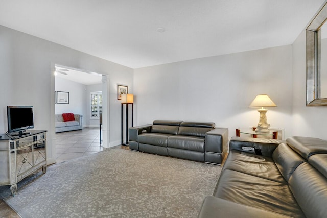 living room featuring light tile patterned floors and vaulted ceiling