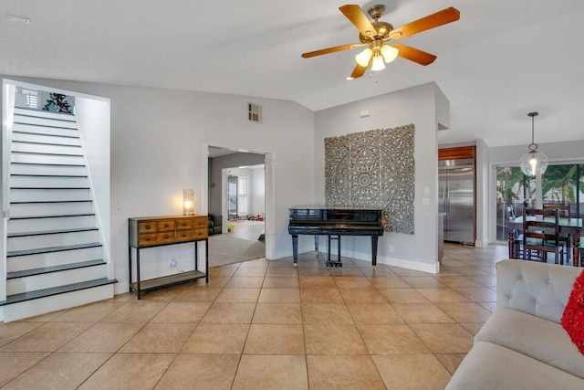 living room featuring ceiling fan, light tile patterned floors, and lofted ceiling