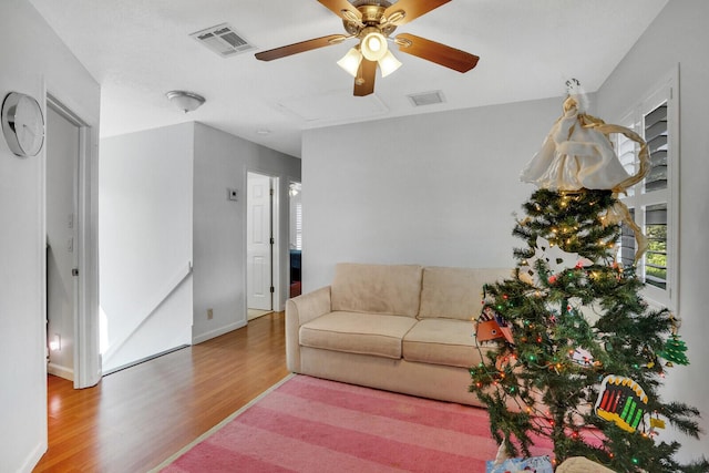 living room featuring wood-type flooring and ceiling fan