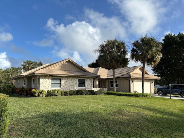 3784 SE Fairway E, Stuart, FL 34997 - ranch-style home with an attached garage, stone siding, a front yard, and driveway