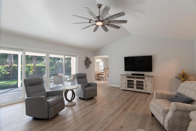 living room featuring light hardwood / wood-style floors, ceiling fan, and lofted ceiling