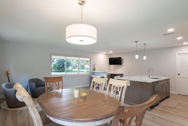 dining room with light hardwood / wood-style floors and sink