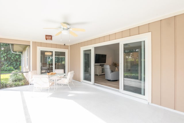 unfurnished sunroom featuring ceiling fan