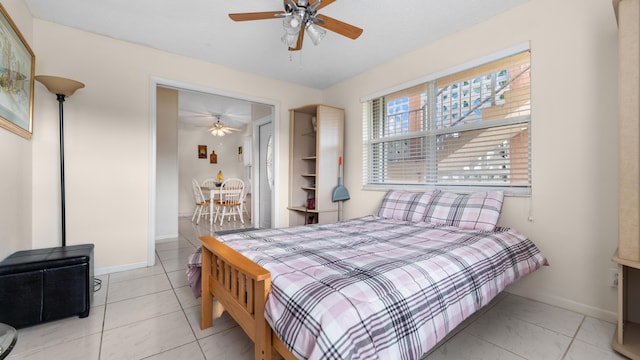 tiled bedroom featuring ceiling fan