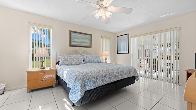 tiled bedroom featuring ceiling fan and a textured ceiling