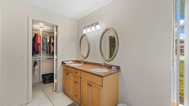 bathroom with a textured ceiling, vanity, and tile patterned floors