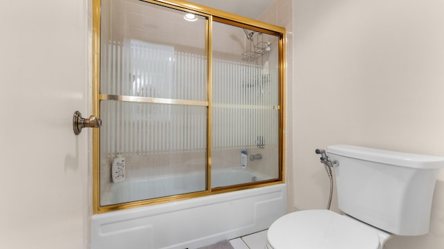 bathroom with tile patterned floors, toilet, and bath / shower combo with glass door