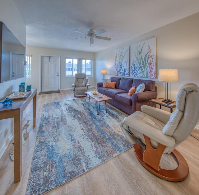 living room with ceiling fan and light hardwood / wood-style flooring