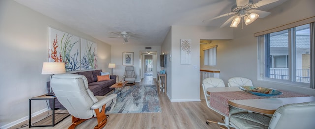 living room featuring light hardwood / wood-style floors and ceiling fan