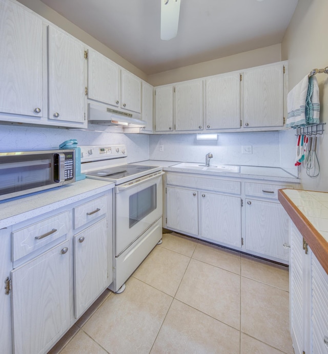 kitchen featuring light tile patterned flooring, sink, white cabinetry, and electric stove