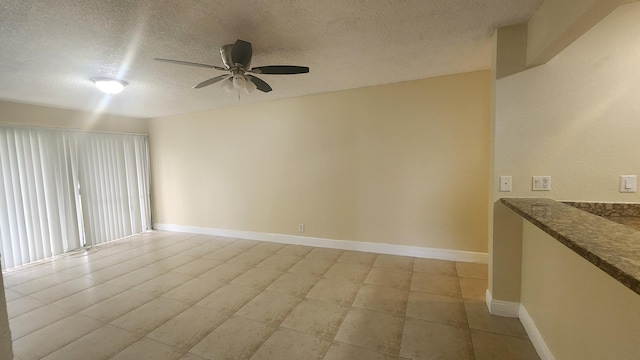 spare room with a textured ceiling and ceiling fan