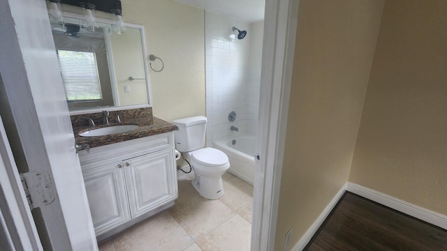 full bathroom featuring tile patterned flooring, vanity, toilet, and tiled shower / bath