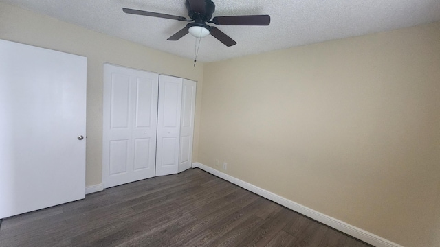 unfurnished bedroom featuring a closet, ceiling fan, dark hardwood / wood-style flooring, and a textured ceiling