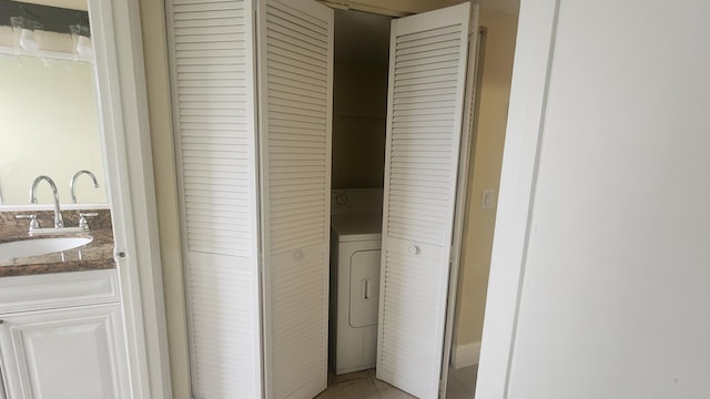 bathroom featuring tile patterned floors, vanity, and washer / clothes dryer