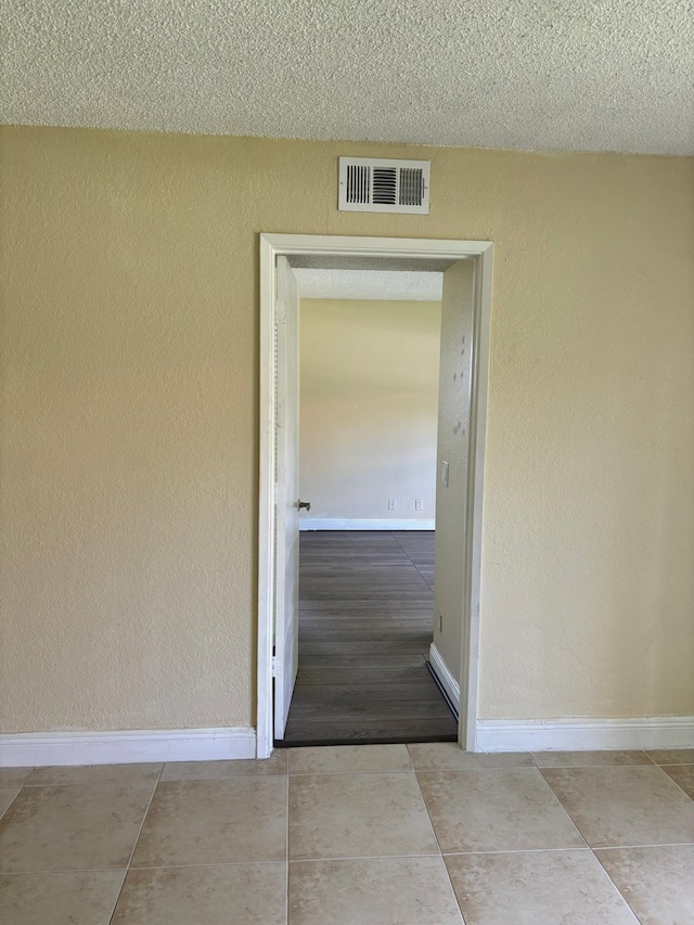 hall featuring a textured ceiling and light wood-type flooring