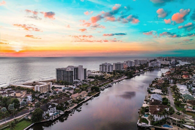 aerial view at dusk featuring a water view