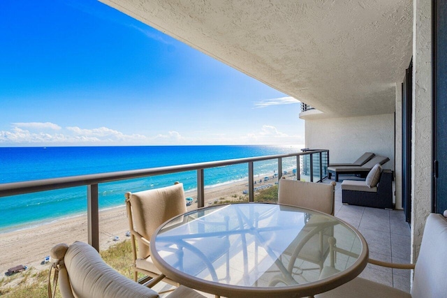 balcony featuring a beach view and a water view