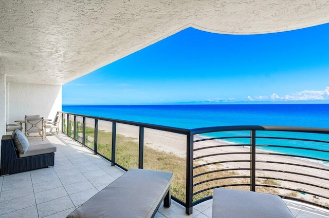 balcony featuring a beach view and a water view