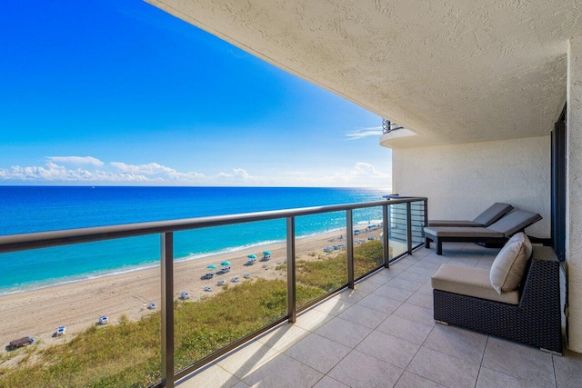 balcony with a water view and a view of the beach