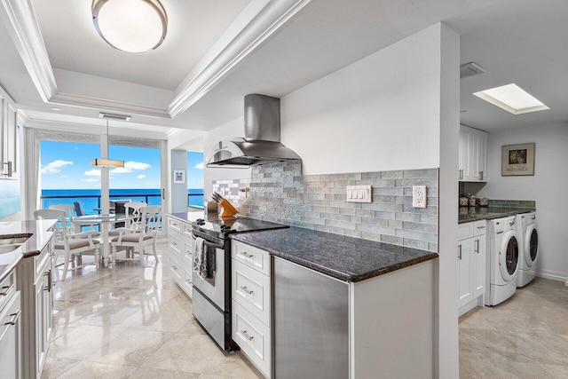 kitchen featuring washer and clothes dryer, wall chimney range hood, white cabinets, stainless steel range with electric stovetop, and a water view