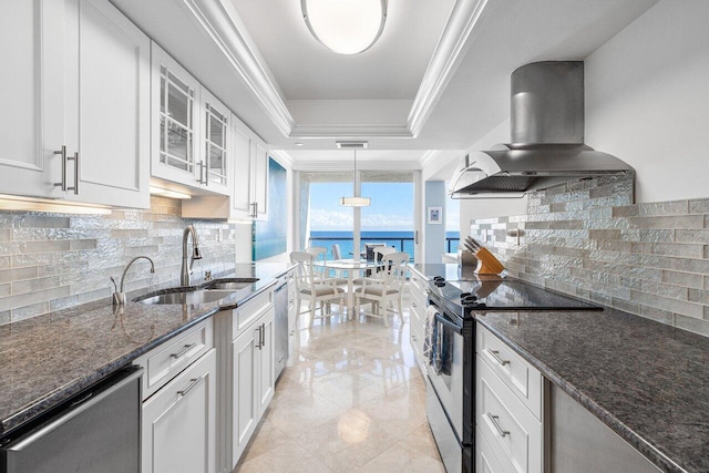 kitchen featuring sink, white cabinets, wall chimney exhaust hood, a water view, and appliances with stainless steel finishes