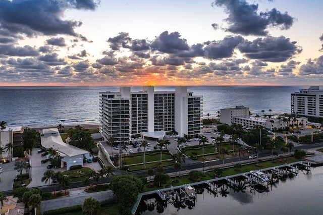 aerial view at dusk featuring a water view