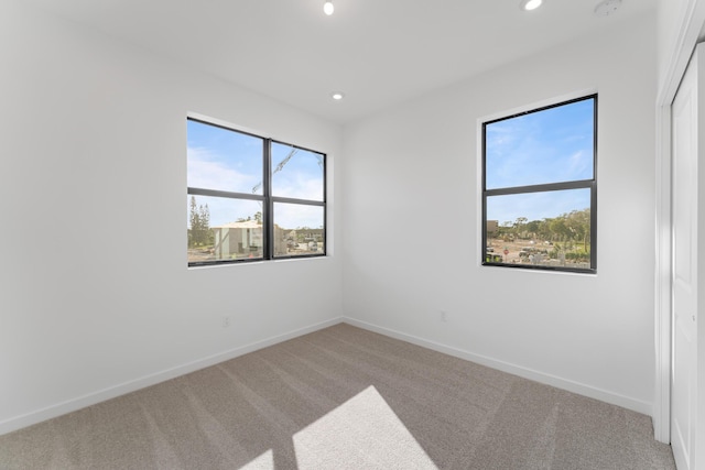 carpeted spare room featuring plenty of natural light