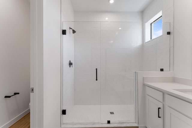 bathroom featuring walk in shower, hardwood / wood-style floors, vanity, and toilet