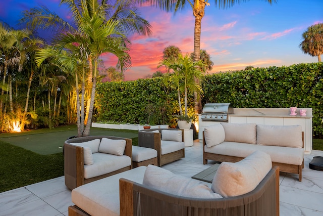 patio terrace at dusk featuring area for grilling