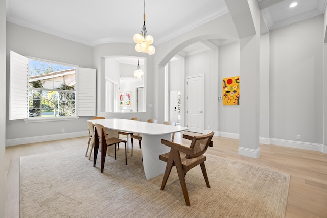 dining space with crown molding, light hardwood / wood-style floors, and a notable chandelier