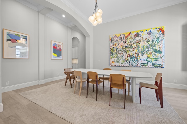 dining area with a chandelier, light hardwood / wood-style flooring, and crown molding