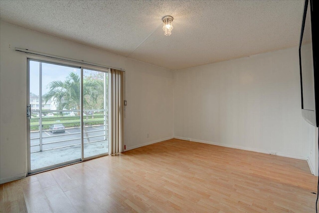 spare room featuring a textured ceiling and light wood-type flooring