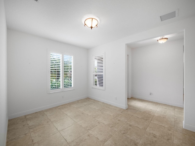 unfurnished room featuring visible vents and baseboards