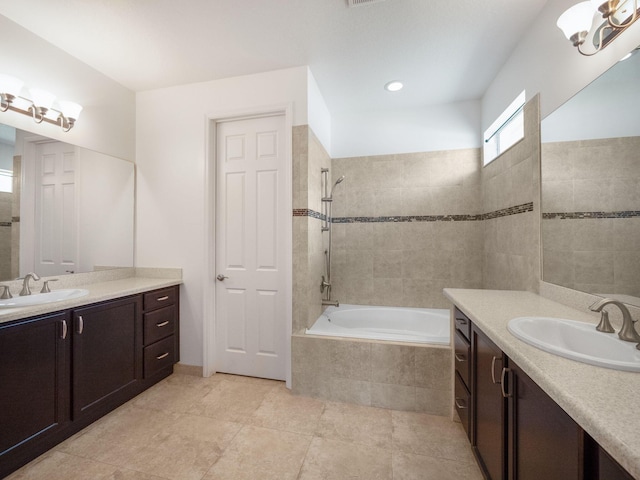 full bathroom featuring two vanities, a sink, tiled shower / bath, and tile patterned floors