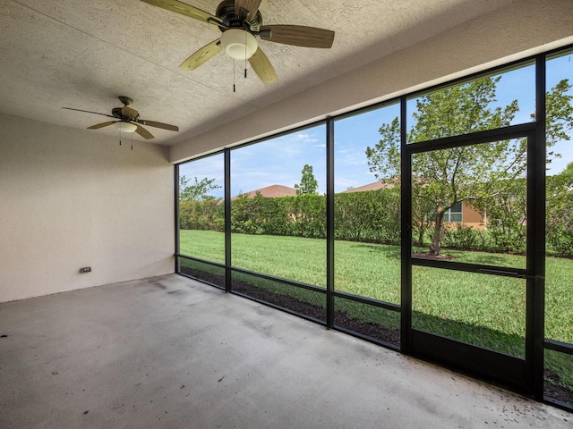 unfurnished sunroom featuring ceiling fan