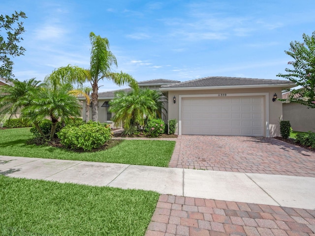 view of front of house featuring a front lawn, decorative driveway, an attached garage, and stucco siding