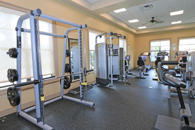 exercise room featuring ceiling fan, visible vents, and a drop ceiling