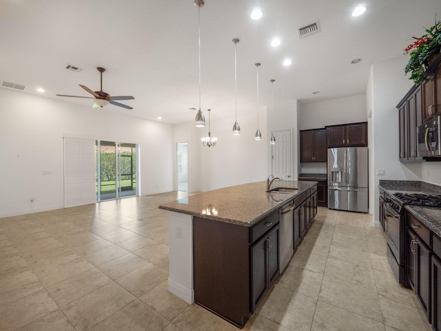 kitchen featuring appliances with stainless steel finishes, visible vents, dark brown cabinets, and an island with sink