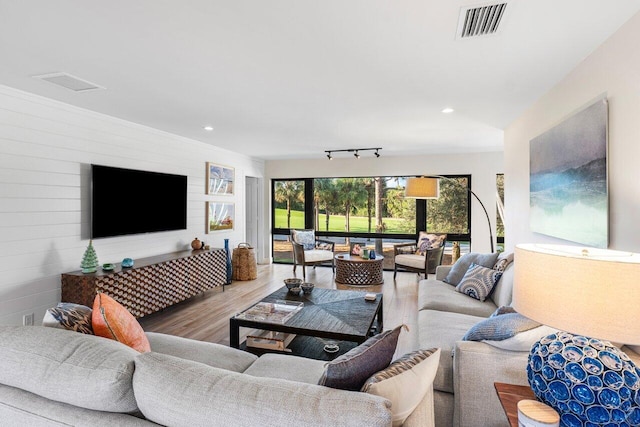 living area with track lighting, visible vents, wood finished floors, and recessed lighting