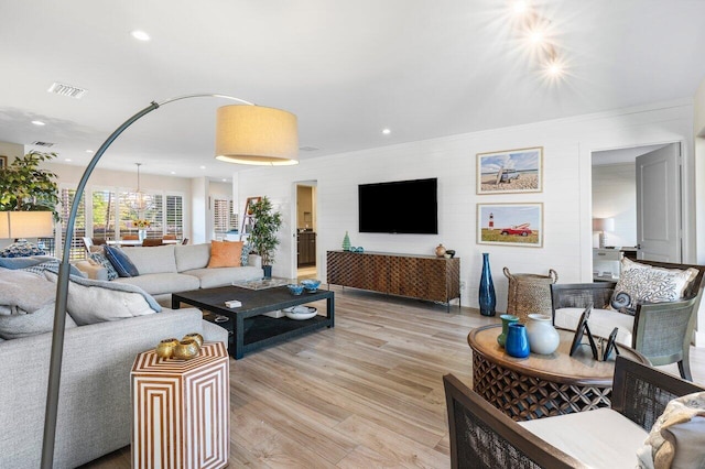 living room with light wood-style flooring, visible vents, and recessed lighting