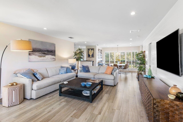 living room with light wood-type flooring and crown molding