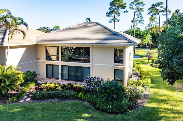 back of property featuring stucco siding and a yard