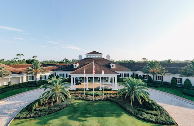 view of front of property with a front lawn, decorative driveway, and a gazebo