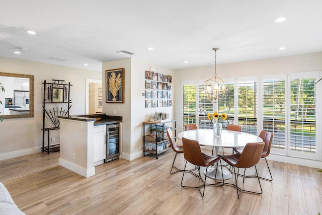 dining space with wine cooler, light wood-type flooring, visible vents, and recessed lighting