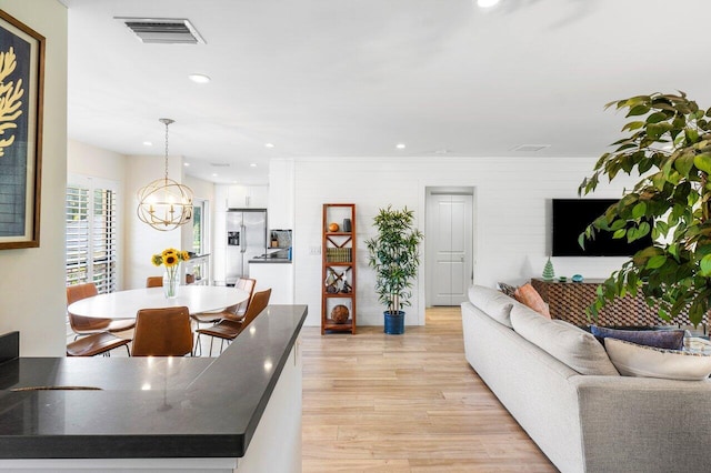 living area featuring a chandelier, light wood-type flooring, visible vents, and recessed lighting