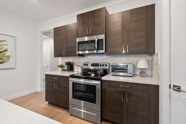 kitchen with light hardwood / wood-style floors, crown molding, dark brown cabinetry, and stainless steel appliances