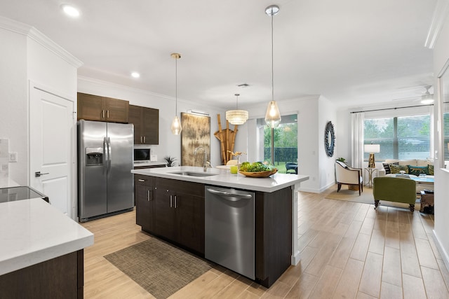 kitchen featuring pendant lighting, sink, an island with sink, dark brown cabinets, and stainless steel appliances